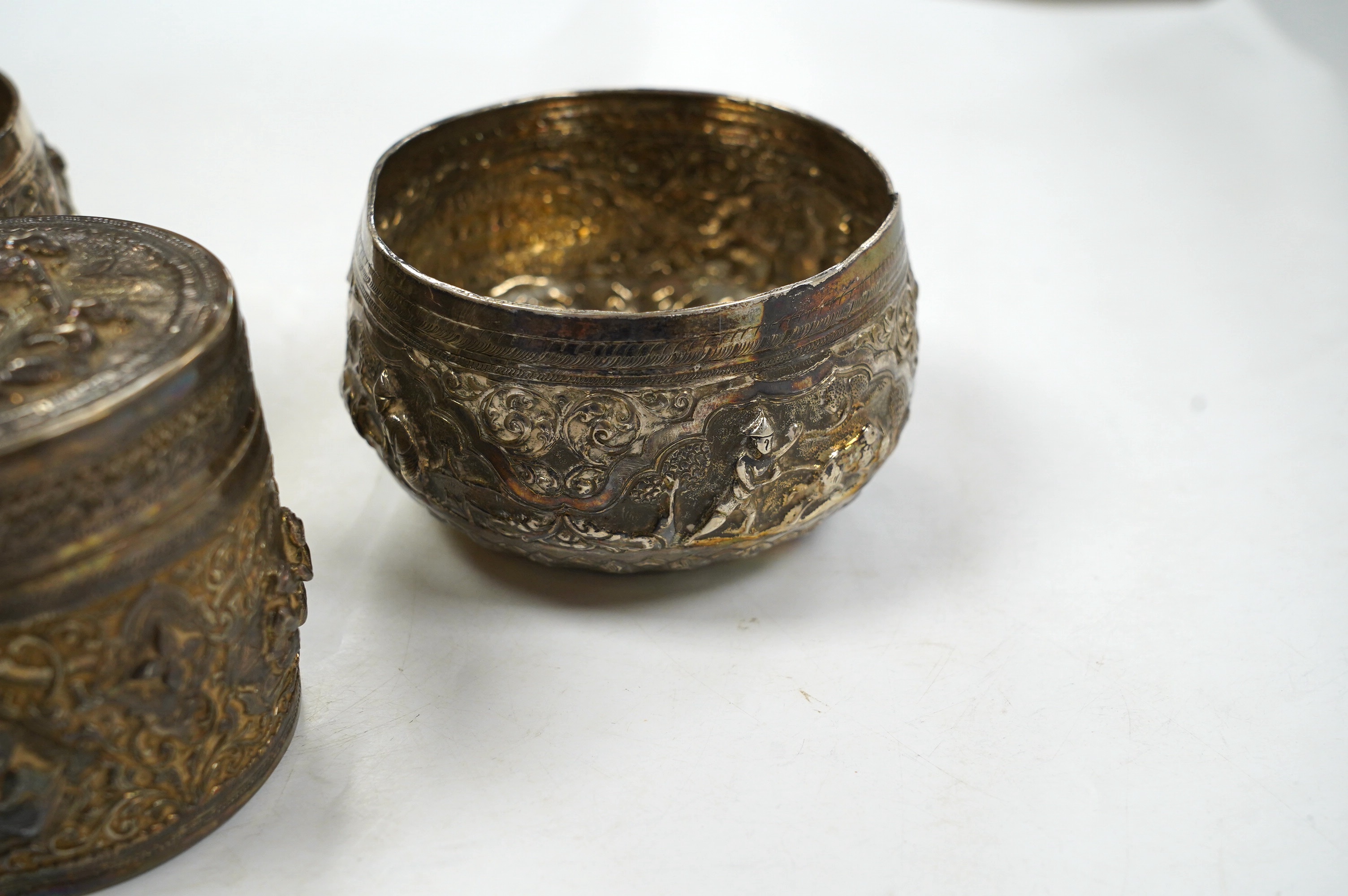 A pair of mid 20th century Indian embossed white metal small bowls, inscribed ' Agri-Horticultural Society Flower Show February 1953', diameter 10.4cm, together with a similar box and cover. Condition - poor to fair